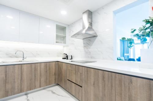a kitchen with wooden cabinets and a sink at S Plaza Suites Hotel in Seef