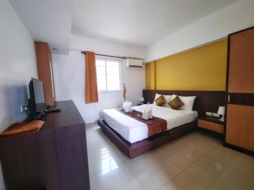 una camera con un letto e una televisione di MM Hill Koh Samui Hotel - SHA Certified a Chaweng Beach
