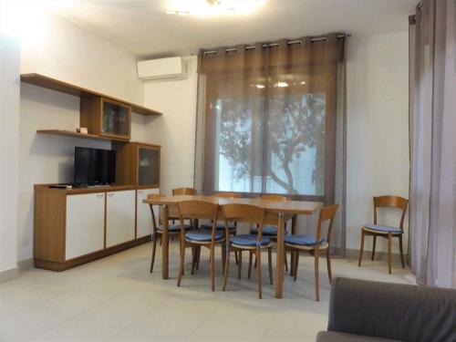 a dining room with a table and chairs and a television at Holiday home in Bibione 36470 in Bibione