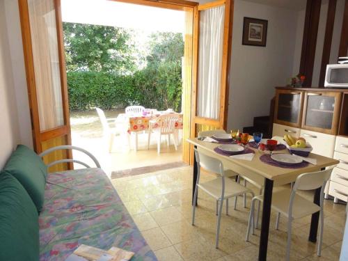ein Wohnzimmer mit einem Tisch und Stühlen sowie eine Küche in der Unterkunft Holiday home in Bibione 38311 in Bibione