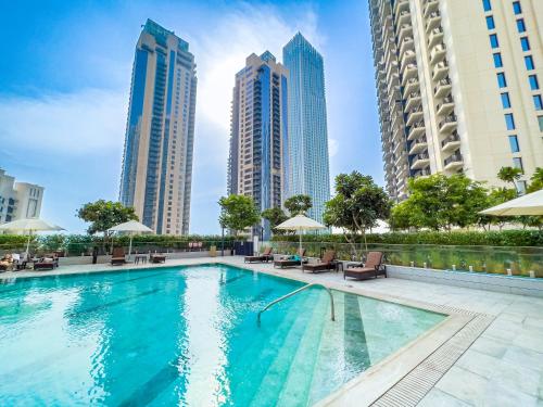 a swimming pool in a city with tall buildings at FAM Living - Creek Horizon - 3B with Kids Room in Dubai