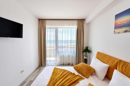 a bedroom with a bed and a large window at Ena Sunrise Summerland in Mamaia