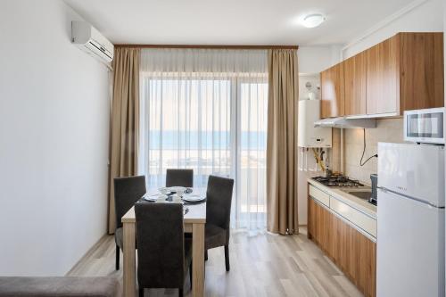 a kitchen and dining room with a table and a refrigerator at Ena Sunrise Summerland in Mamaia