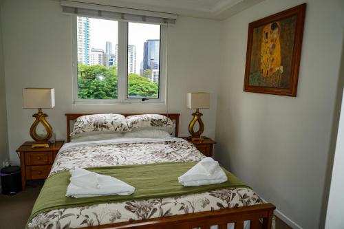 a bedroom with a bed and a window with a view at City/Valley Resort Apartment in Brisbane