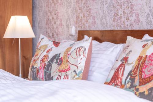 a bed with white sheets and pillows and a lamp at Hotel Viva Sky in Konstanz