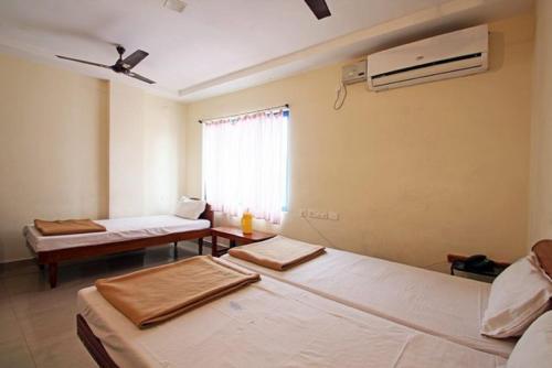 a room with two beds and a window at Bhanu Residency in Tirupati