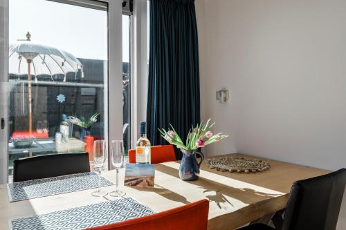 a dining room table with a laptop on top of it at Strandhuis de Zeeparel met hottub in Petten