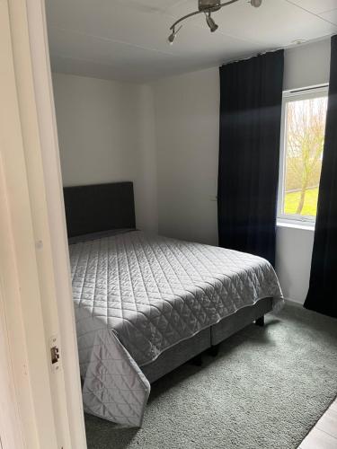 um quarto com uma cama em um quarto com janela em Nära till allt em Falkenberg