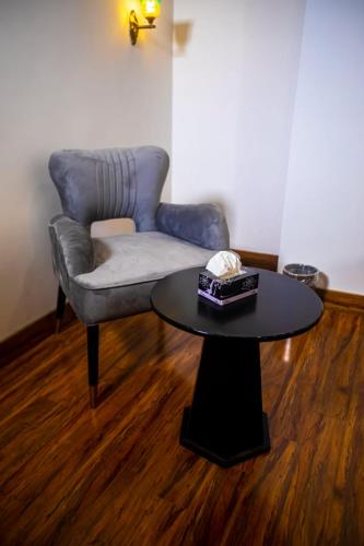 a living room with a chair and a table at The Rich Hotel & Apartments in Lahore