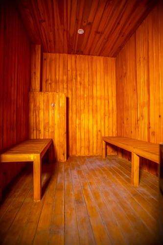 an empty wooden room with two benches in it at The Rich Hotel & Apartments in Lahore
