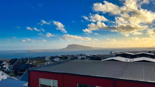 a view of a town with a mountain in the background at New Aparthotel / Panoramic sea view in Tórshavn