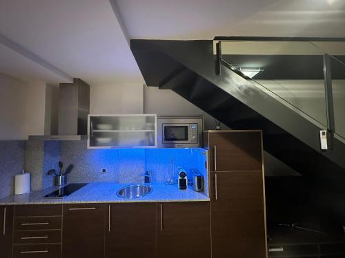 uma cozinha com um balcão azul e um lavatório em Precioso dúplex en el centro de Tarragona em Tarragona