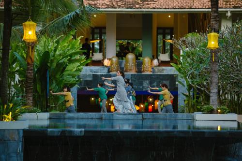 a group of people standing around a fountain at Almanity Hoi An Resort & Spa in Hoi An