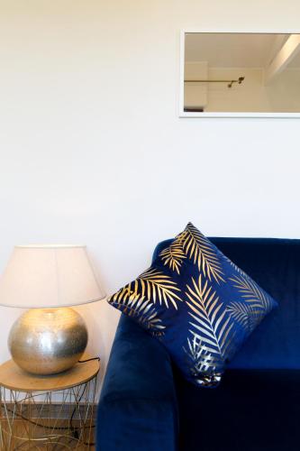 a blue couch with a pillow next to a lamp at Villa d exception avec terrasse, jacuzzi, vue mer, parking, en plein cœur du village de Eze in Éze