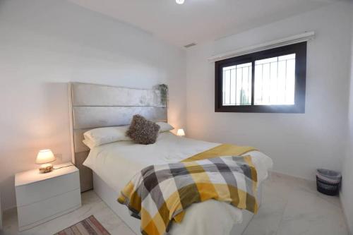 ein weißes Schlafzimmer mit einem Bett und einem Fenster in der Unterkunft Apartamento Perdiz. Perfecto. in San Juan de los Terreros