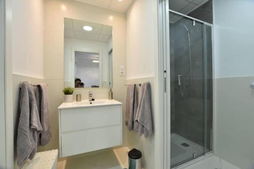 ein Bad mit einem Waschbecken und einer Glasdusche in der Unterkunft Apartamento Perdiz. Perfecto. in San Juan de los Terreros