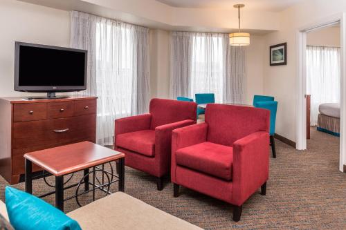 a hotel room with red chairs and a flat screen tv at Residence Inn Pittsburgh North Shore in Pittsburgh