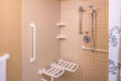 baño con paredes de azulejos blancos y ducha. en Residence Inn Pittsburgh North Shore, en Pittsburgh