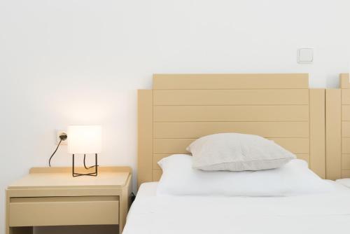 a bedroom with a bed and a lamp on a nightstand at Kristina Stelios Apartment in Plataniás