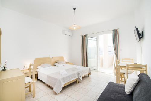 a bedroom with a bed and a living room at Kristina Stelios Apartment in Plataniás