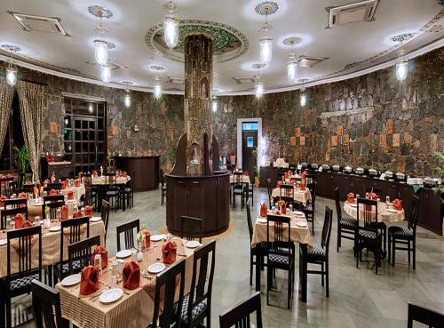 a restaurant with tables and chairs in a room at The Amargarh in Udaipur