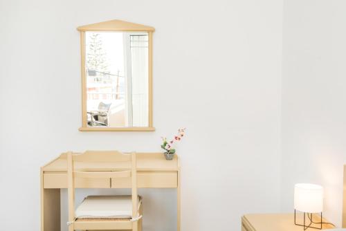 a desk and chair in a room with a mirror at Kristina Stelios Apartment in Plataniás