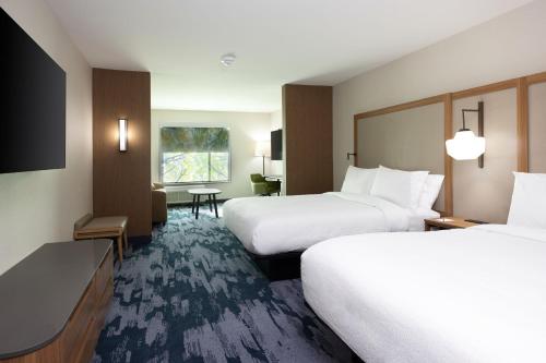 a hotel room with two beds and a television at Fairfield by Marriott Inn & Suites Canton Riverstone Parkway in Canton