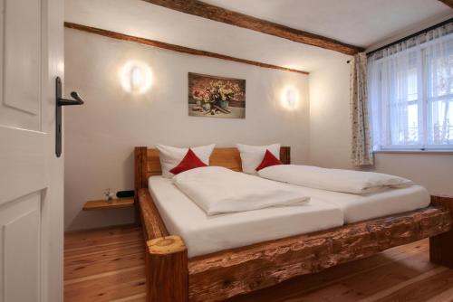 een slaapkamer met een houten bed met witte en rode kussens bij Jurahaus Pröll Ottmaring in Dietfurt