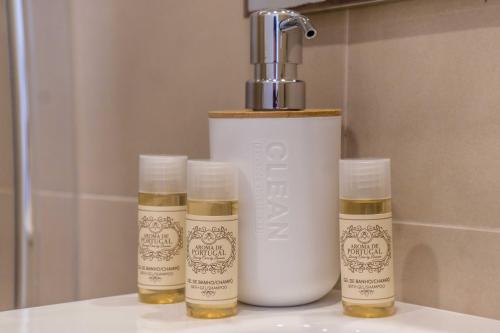 a group of three bottles of essential oils sitting next to a bathroomilit at Vistamar Apartments in Portimão