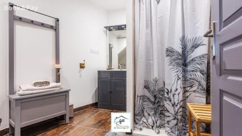 ein Badezimmer mit einem Duschvorhang neben einem Waschbecken in der Unterkunft Les Salamandres de Beauregard in Cuq-Toulza