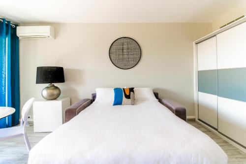 1 dormitorio con 1 cama y 1 mesa en SELECT'SO HOME - Studio au cœur du Lavandou-Services hôteliers-AREV, en Le Lavandou