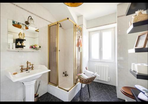 La salle de bains blanche est pourvue d'une douche et d'un lavabo. dans l'établissement Villa Bonnabel, à Nancy