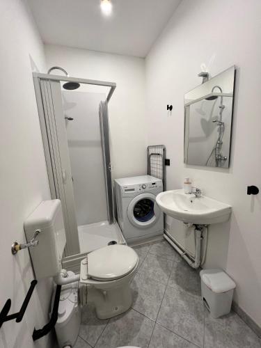 a bathroom with a toilet sink and a washing machine at Affittacamere Viali centro Chivasso in Chivasso