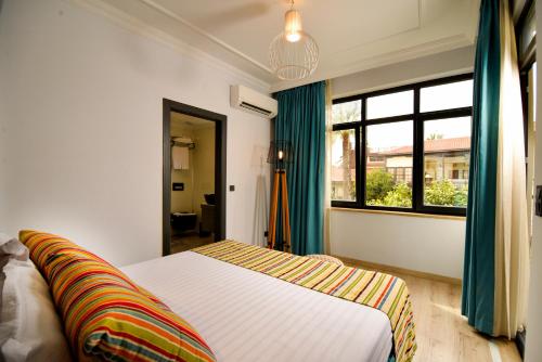 a bedroom with a bed and a window at Remarkable Flat with Balcony near Hadrian's Gate in Antalya