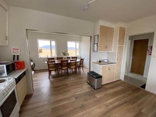 a kitchen and dining room with a table and chairs at Álftártunga Farm Guesthouse in Borgarnes