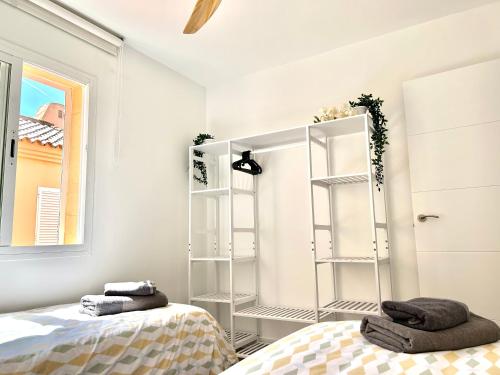 a bedroom with two beds and a mirror at Apartamento Los Lances en Primera línea de playa con piscina in Tarifa