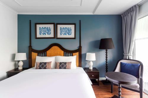a bedroom with a bed and a blue wall at Away Chiang Mai Thapae Resort A Vegan Retreat in Chiang Mai