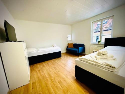 Habitación con 2 camas y silla azul en Apartment Goldschmied, en Schwabach