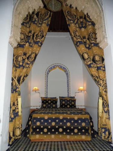 a bedroom with a bed with an ornate ceiling at Riad Marco Andaluz in Sale