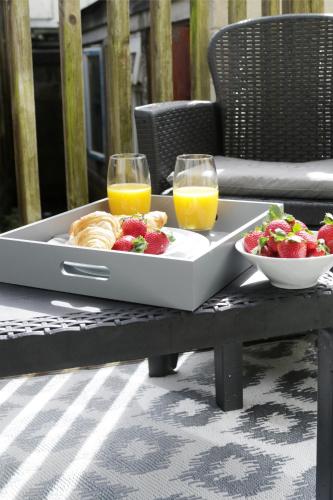 a tray of food with fruit and two glasses of orange juice at Apartments in the heart of Penzance in Penzance