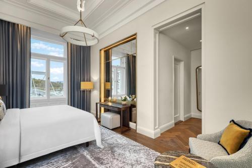 a bedroom with a large white bed and a couch at Matild Palace, a Luxury Collection Hotel in Budapest