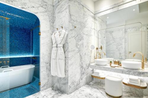 a bathroom with two sinks and a tub and a bath tub at Matild Palace, a Luxury Collection Hotel in Budapest