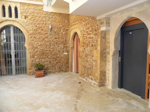 a room with a stone wall and a black door at Riad Marco Andaluz in Sale