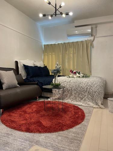 a living room with a couch and a red rug at BEST LOCATED SHINJUKU CENTRAL Full-Furnished APARTMENT 3minWalk to Station1 in Tokyo