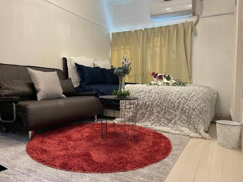 a living room with a couch and a red rug at BEST LOCATED SHINJUKU CENTRAL Full-Furnished APARTMENT 3minWalk to Station1 in Tokyo