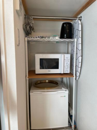 a microwave and a washer and dryer in a kitchen at BEST LOCATED SHINJUKU CENTRAL Full-Furnished APARTMENT 3minWalk to Station1 in Tokyo