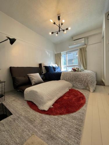 a living room with a couch and a red rug at BEST LOCATED SHINJUKU CENTRAL Full-Furnished APARTMENT 3minWalk to Station1 in Tokyo
