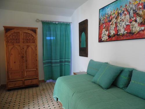 a living room with a green couch and a door at Riad Marco Andaluz in Sale