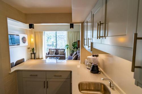 a kitchen with a sink and a living room at Marriott Port-au-Prince Hotel in Port-au-Prince