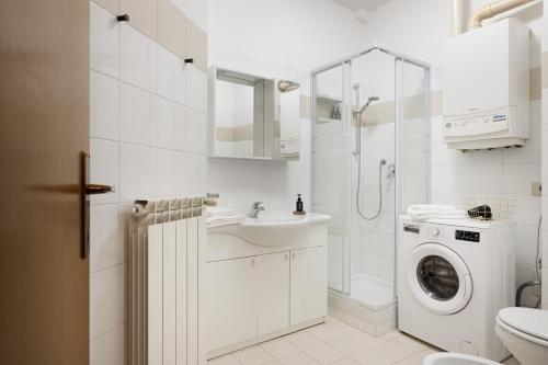biała łazienka z umywalką i pralką w obiekcie Suite Foscolo, comfort con box auto a Trieste w Trieście